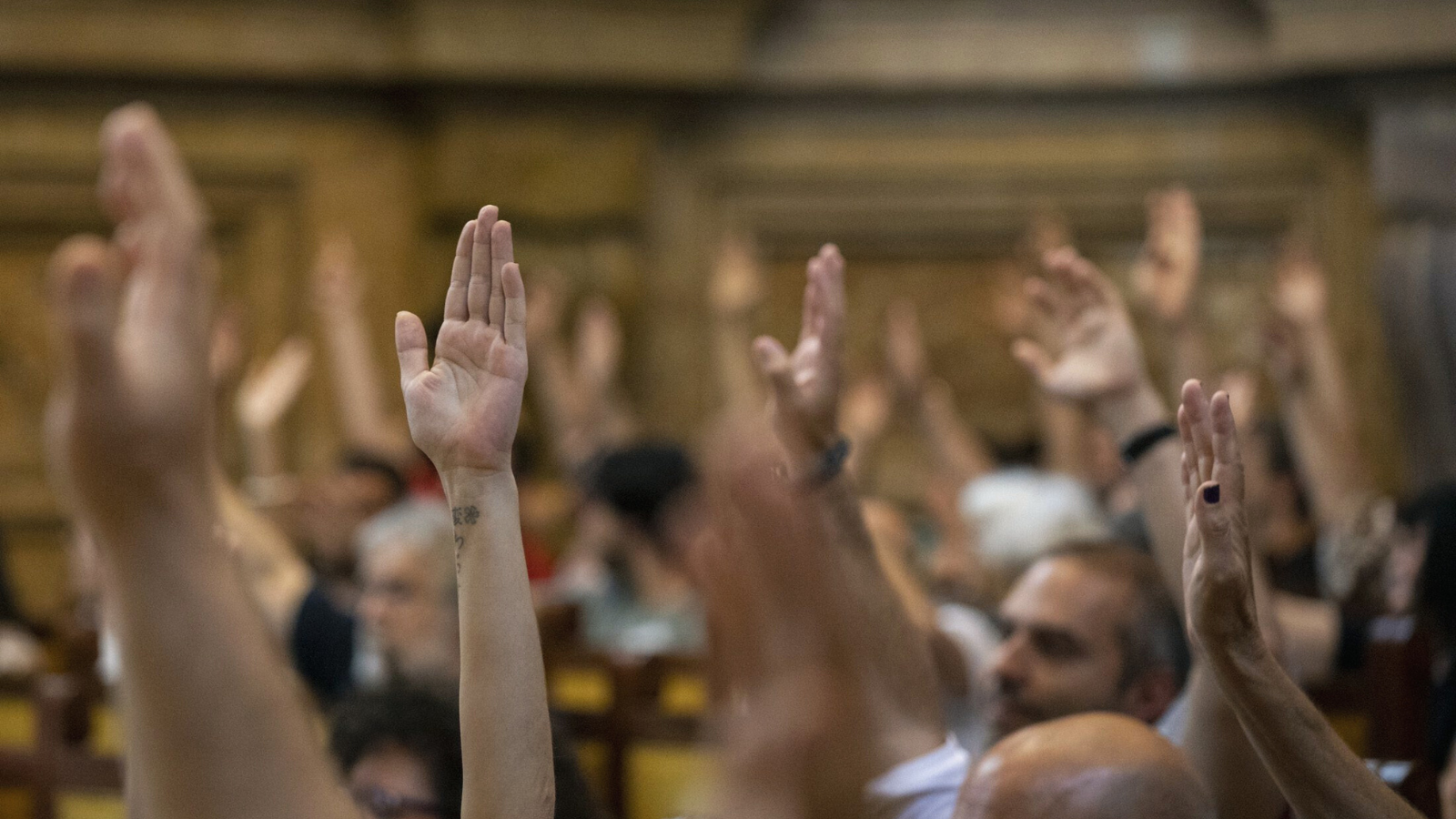 Fotografía en la UCM de manos levantadas en una votación